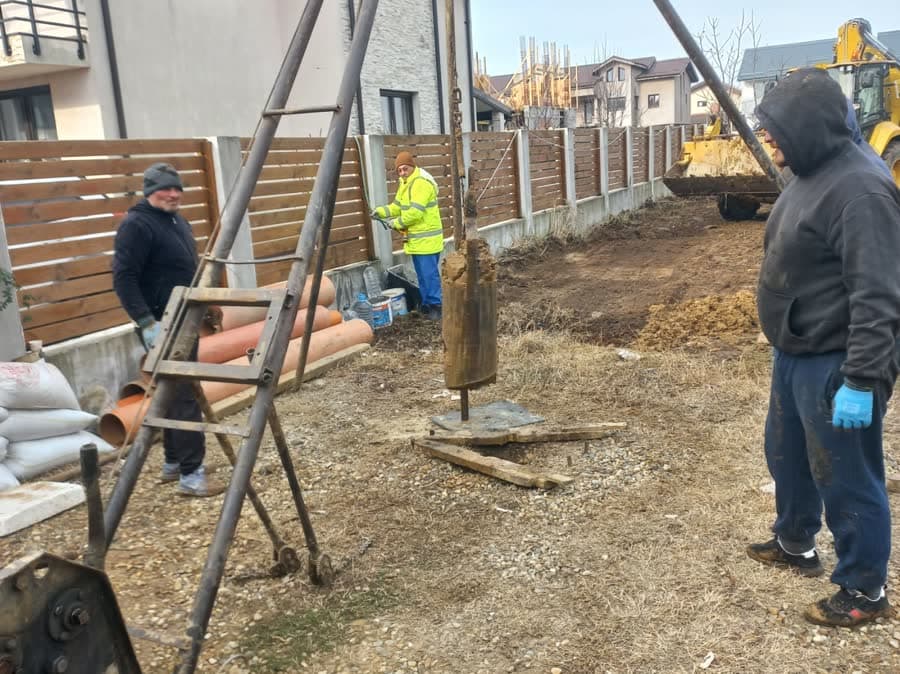 Echipă de foraj la lucru în curtea unei case