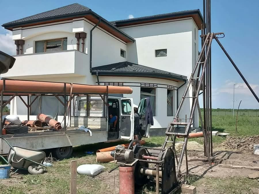 Instalație de foraj montată lângă o casă